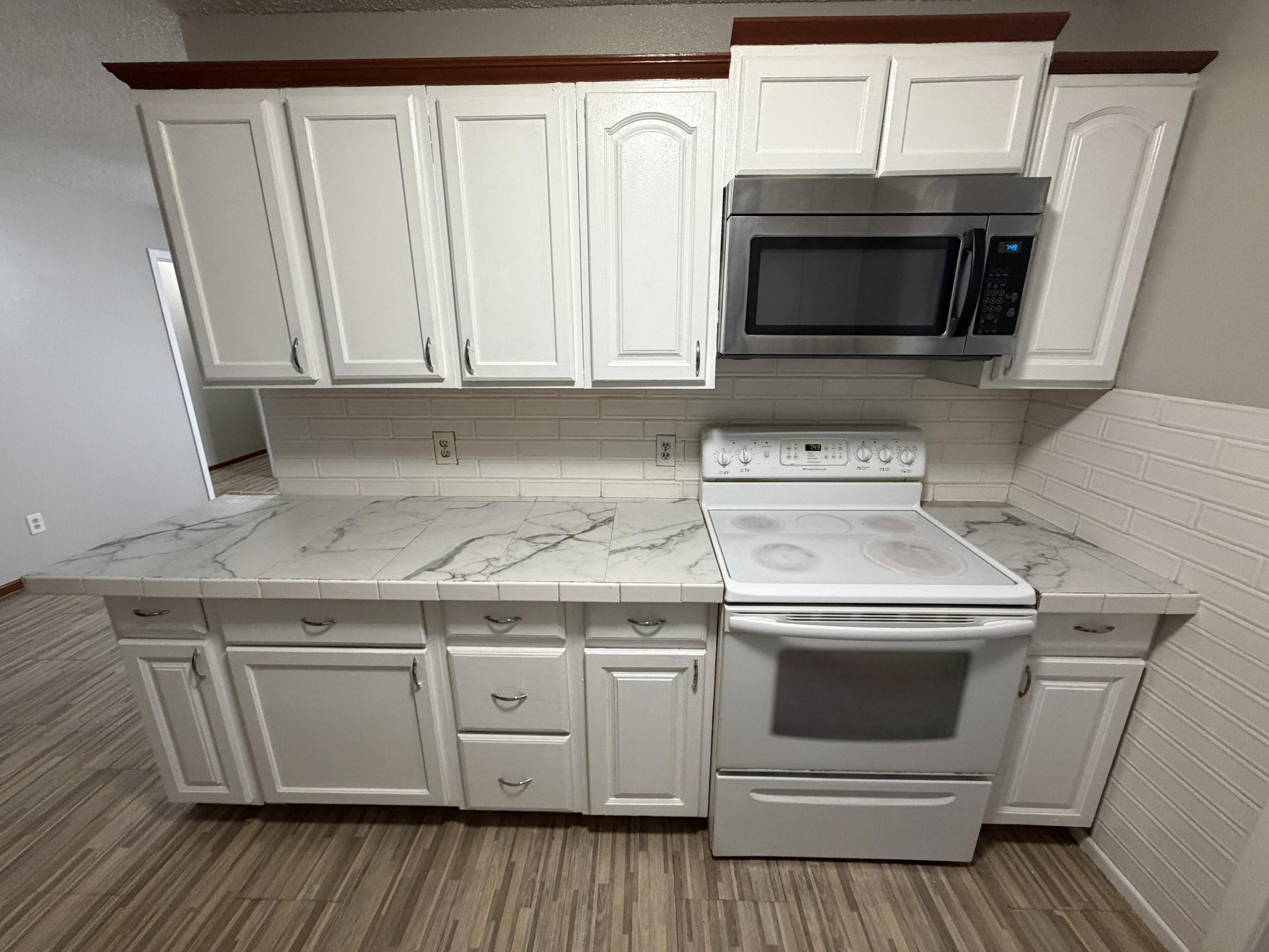 5720 46th Street Lubbock, TX 79414 - Photo 9 of 23 a kitchen with white cabinets stainless steel appliances and sink