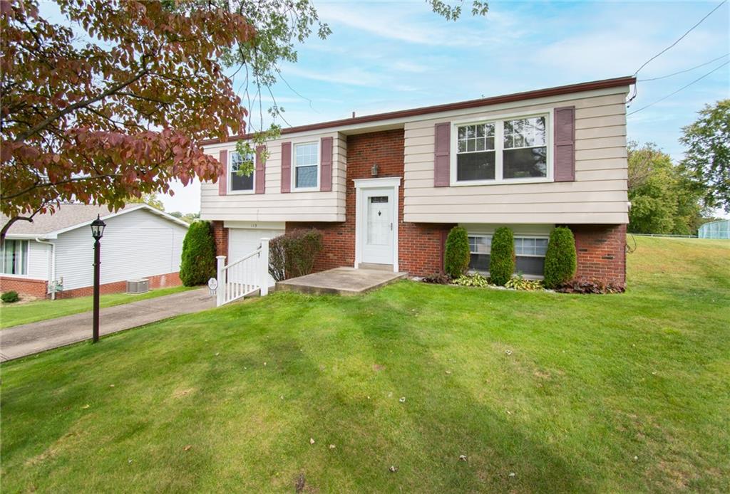 a view of an house with backyard and a tree