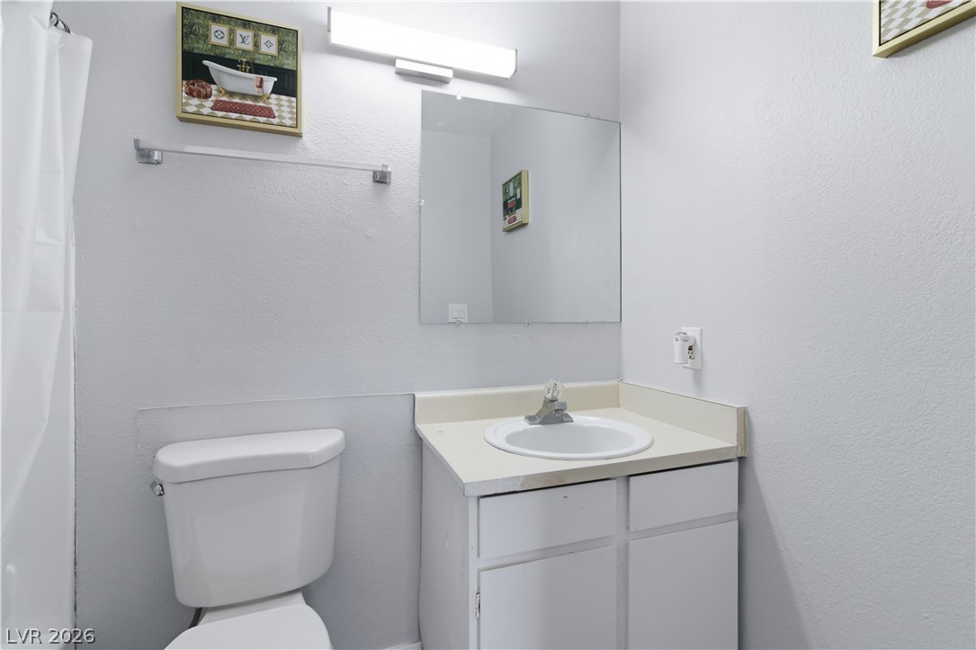 2221 West Bonanza Road, Unit 28 Las Vegas, NV 89106 - Photo 8 of 15 This bright bathroom features a vanity, mirror, and toilet, offering essential comfort and utility.