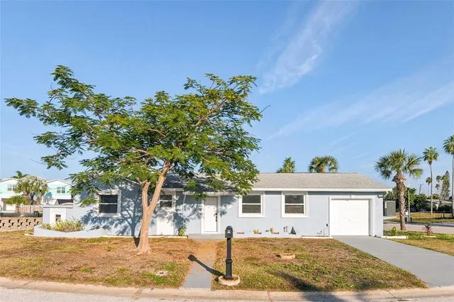 a front view of a house with a yard and potted plants