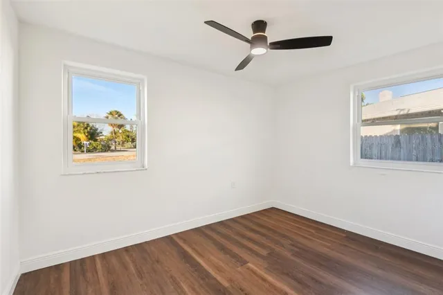 a view of a hallway with wooden floor and a window