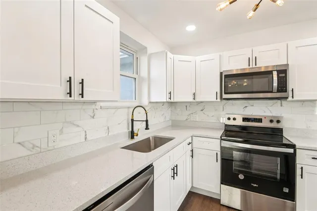 a kitchen with stainless steel appliances a stove a sink a microwave and cabinets