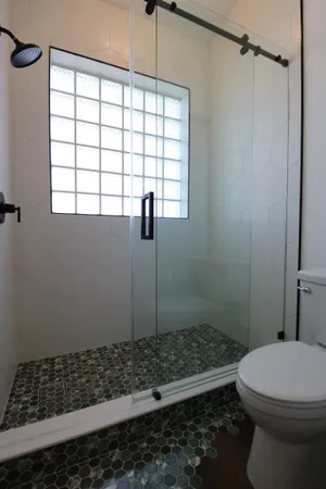a bathroom with a sink a toilet and shower