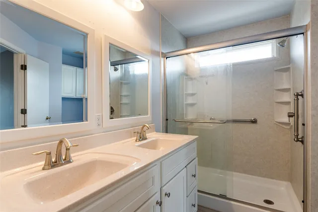 a bathroom with a shower sink and mirror