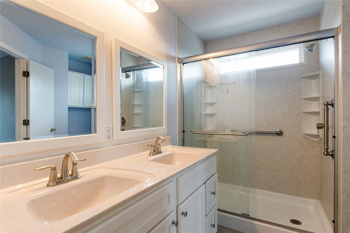 1329 Amberwood Loop Kyle, TX 78640 - Photo 20 of 25 a bathroom with a shower sink and mirror