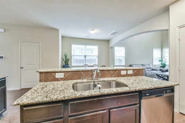 a kitchen with granite countertop a sink and white cabinets