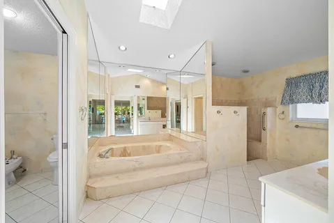 a spacious bathroom with a tub shower and sink