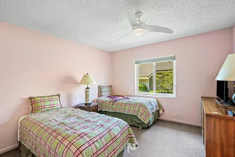 a bedroom with two beds and a chandelier