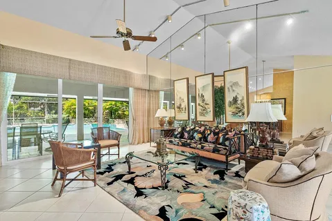 a living room with furniture ceiling fan and a large window
