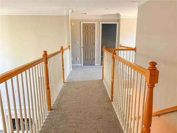 a view of a hallway with wooden floor and staircase