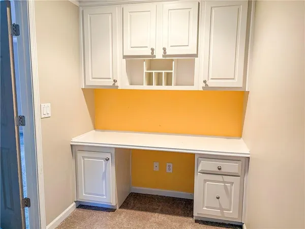 a view of kitchen with wooden floor and cabinets
