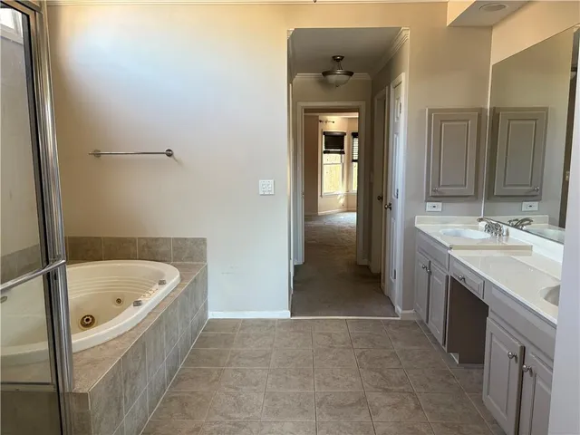 a bathroom with a tub sink and mirror