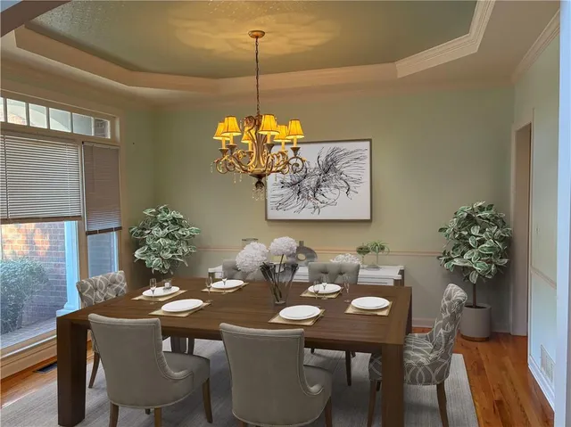 a view of a dining room with furniture wooden floor and chandelier