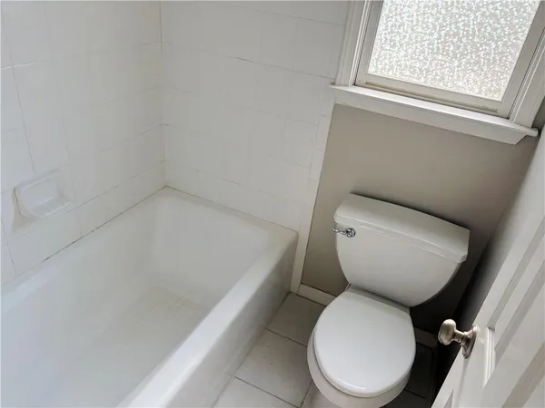 a white toilet sitting next to a window