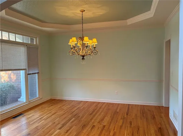 a view of a room with wooden floor chandeliers and a ceiling fan