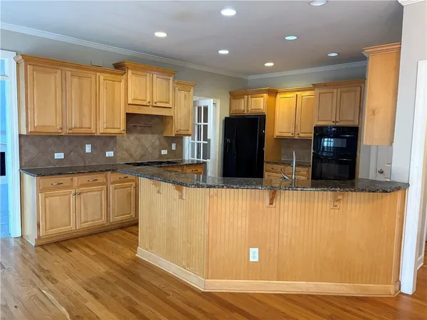 a large kitchen with stainless steel appliances granite countertop a stove a sink and a refrigerator