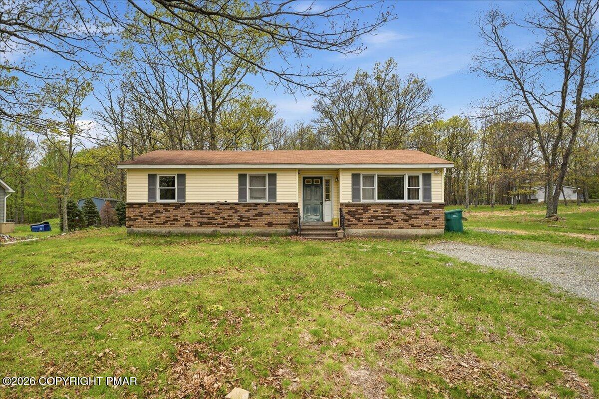 520 Hummingbird Court Bushkill, PA 18324 - Photo 1 of 17 a front view of a house with a yard table and chairs