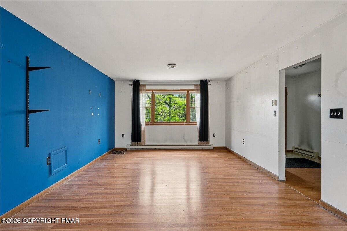 520 Hummingbird Court Bushkill, PA 18324 - Photo 4 of 17 a view of an empty room with window and wooden floor