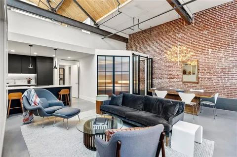 a living room with furniture a flat screen tv and large window