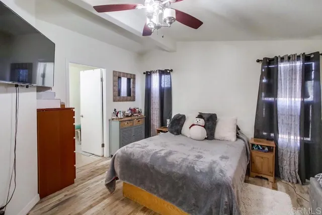 a bedroom with a bed dresser and wooden floor