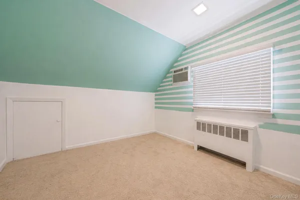a utility room with a bed and wooden floor