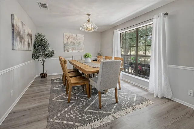 a bedroom with a bed a large window and a chandelier