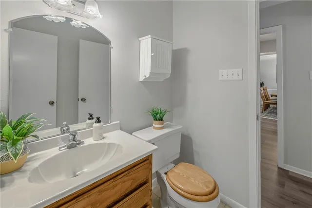 a bathroom with a granite countertop sink a toilet and a mirror