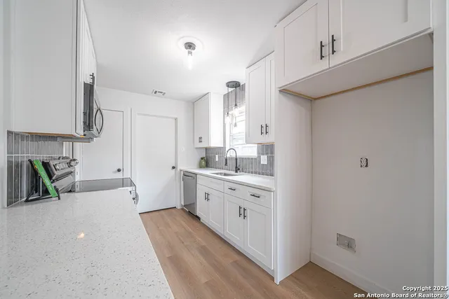a kitchen with sink a stove and cabinets