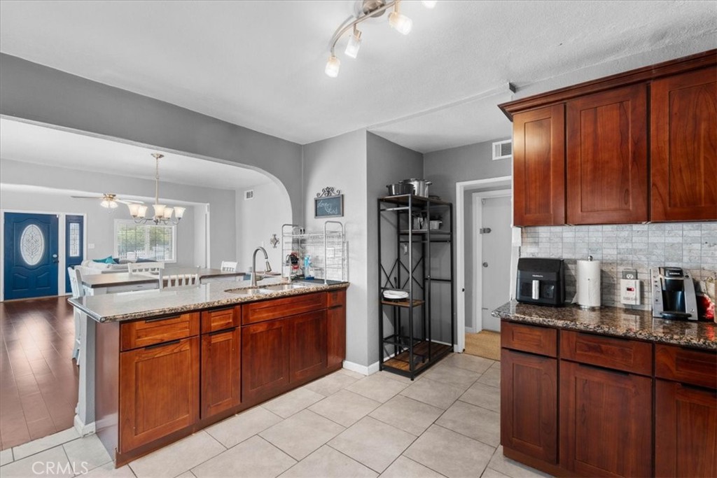 3974 5th Street Riverside, CA 92501 - Photo 15 of 45 a kitchen with stainless steel appliances granite countertop wooden cabinets a sink and dishwasher