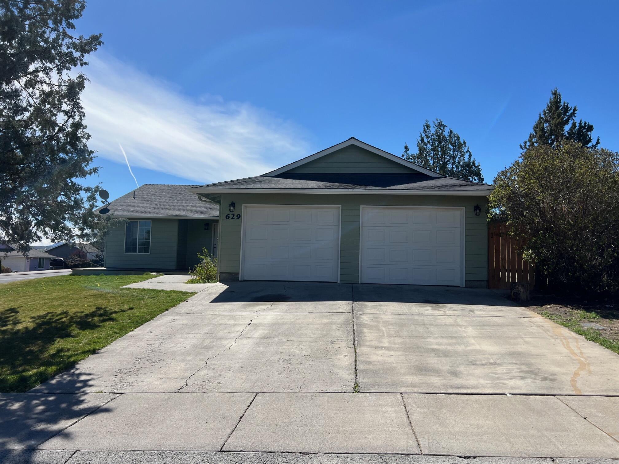 629 Deer Ridge Court Madras, OR 97741 - Photo 2 of 39 a front view of a house with a yard and garage