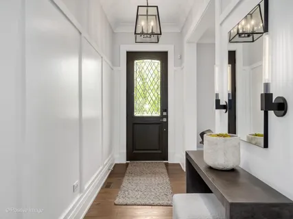 a view of a hallway with wooden floor and entryway