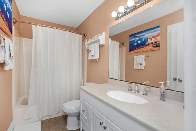 a bathroom with a granite countertop sink toilet and a mirror