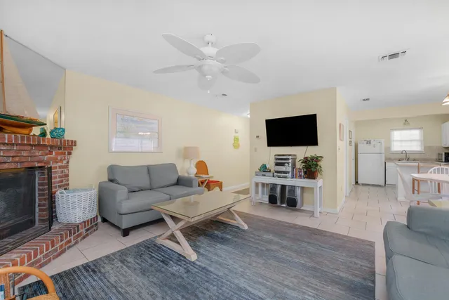 a living room with furniture a flat screen tv and a fireplace