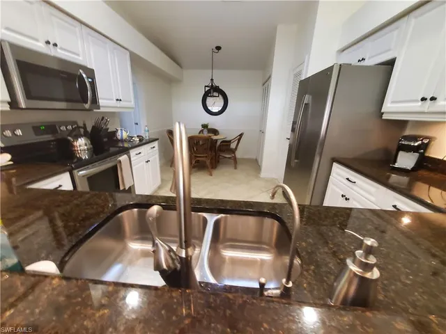 a kitchen with a sink appliances and cabinets