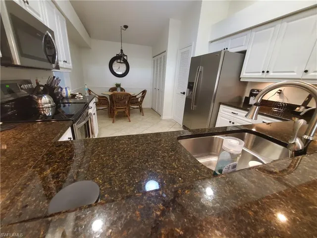 a kitchen with granite countertop a sink a stove and a microwave