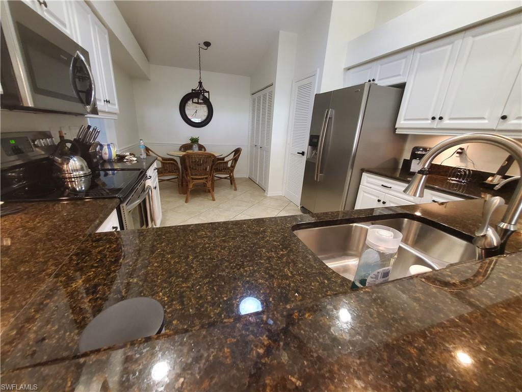 992 Marblehead Drive Naples, FL 34104 - Photo 13 of 50 a kitchen with granite countertop a sink a stove and a microwave