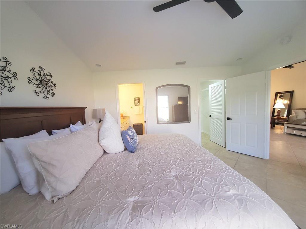 992 Marblehead Drive Naples, FL 34104 - Photo 30 of 50 a bedroom with a large bed and a chandelier