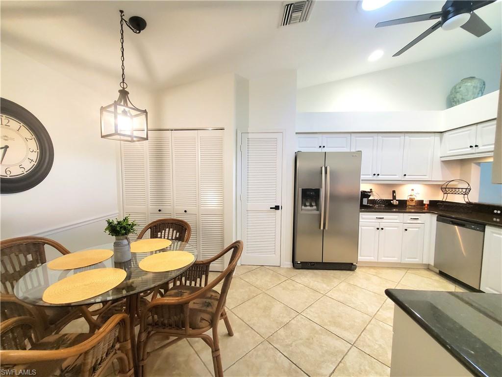 992 Marblehead Drive Naples, FL 34104 - Photo 4 of 50 a kitchen with stainless steel appliances granite countertop a dining table chairs and a refrigerator