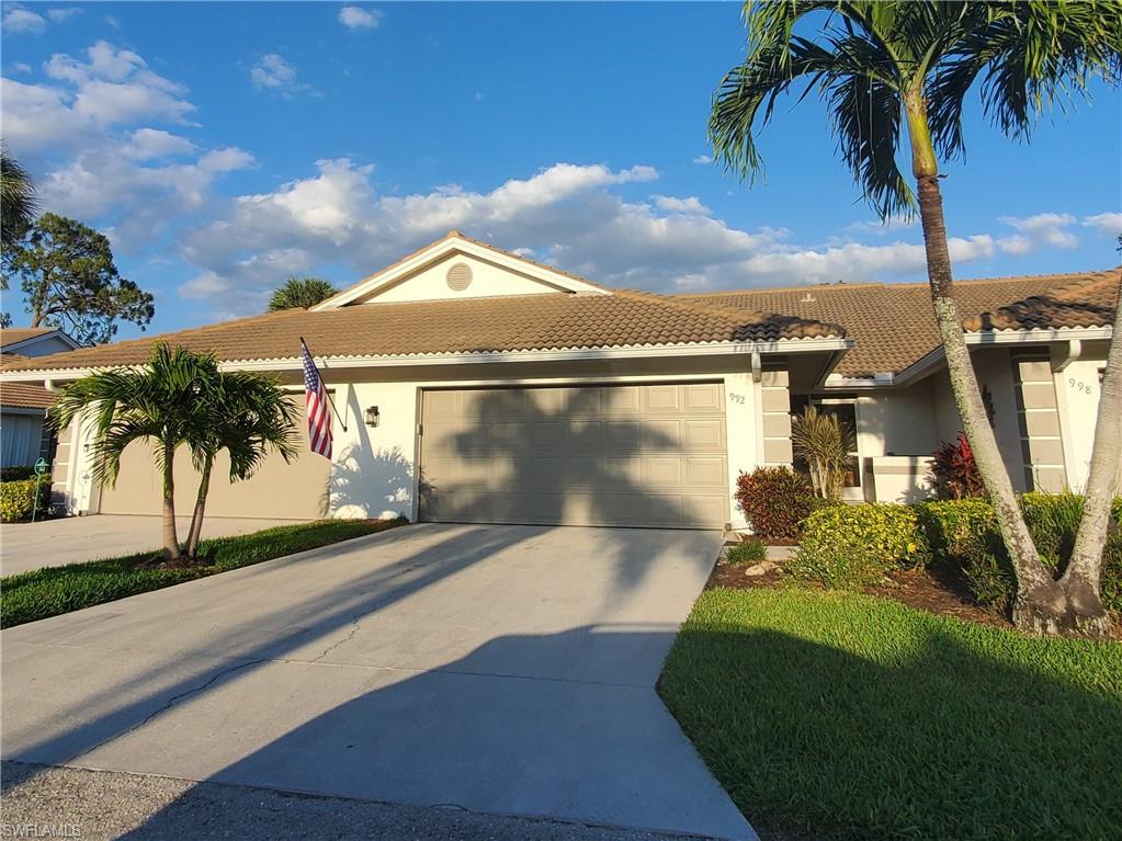 992 Marblehead Drive Naples, FL 34104 - Photo 45 of 50 a front view of a house with a yard and garage