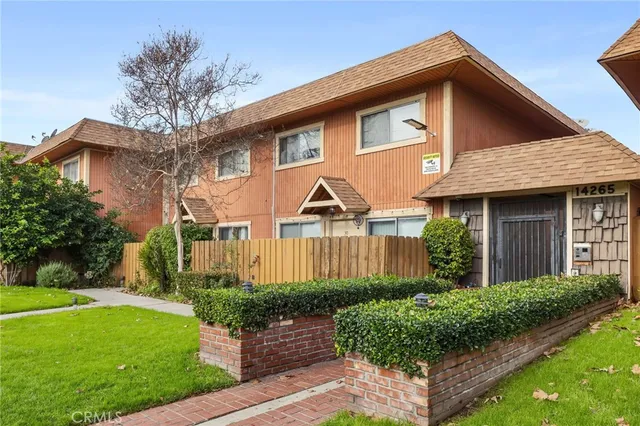 a front view of a house with a yard and potted plants