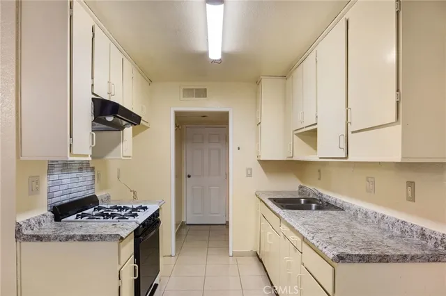 a kitchen with a stove top oven sink and cabinets