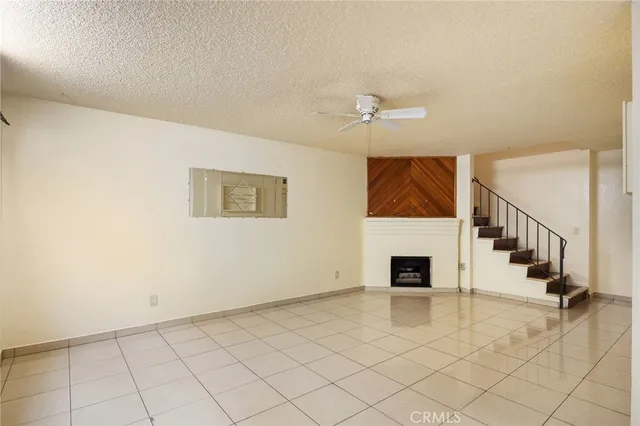 a view of an empty room with wooden floor and a fireplace