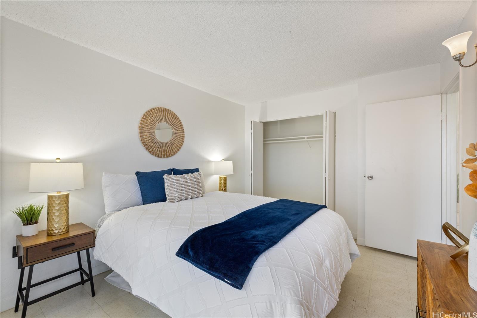 87-119 Helelua Street, Unit F204 Waianae, HI 96792 - Photo 13 of 24 a bedroom with a bed and a lamp on dresser