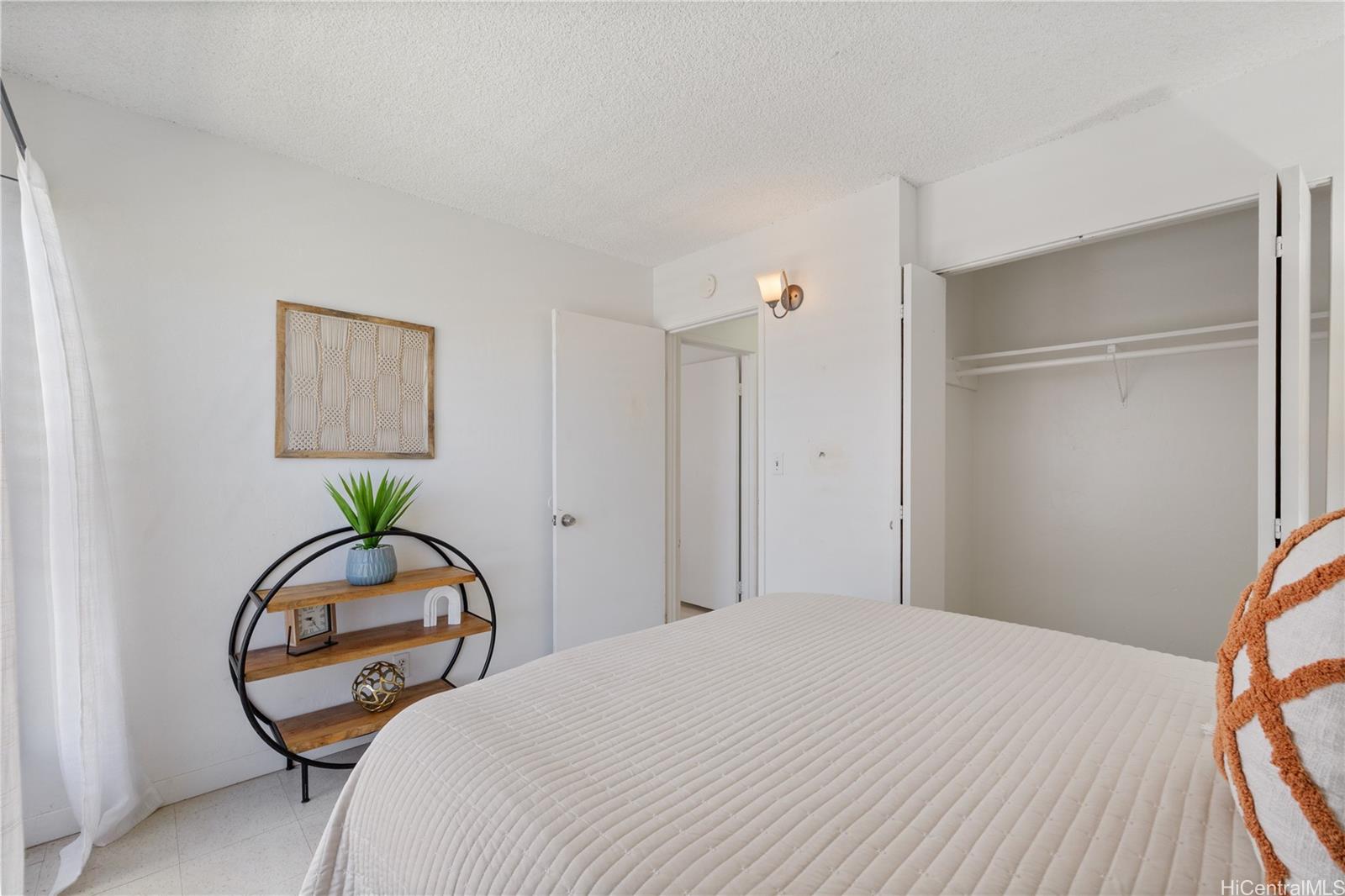 87-119 Helelua Street, Unit F204 Waianae, HI 96792 - Photo 16 of 24 a bedroom with a bed and a chandelier