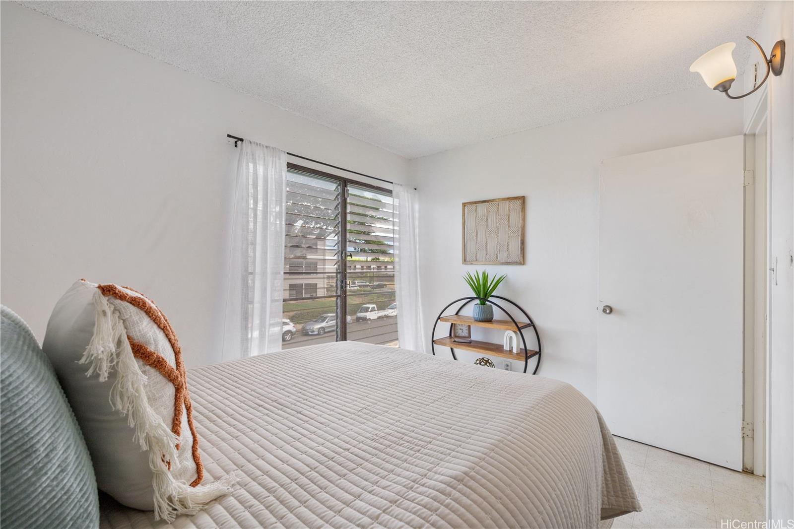 87-119 Helelua Street, Unit F204 Waianae, HI 96792 - Photo 17 of 24 a bedroom with a bed and a window