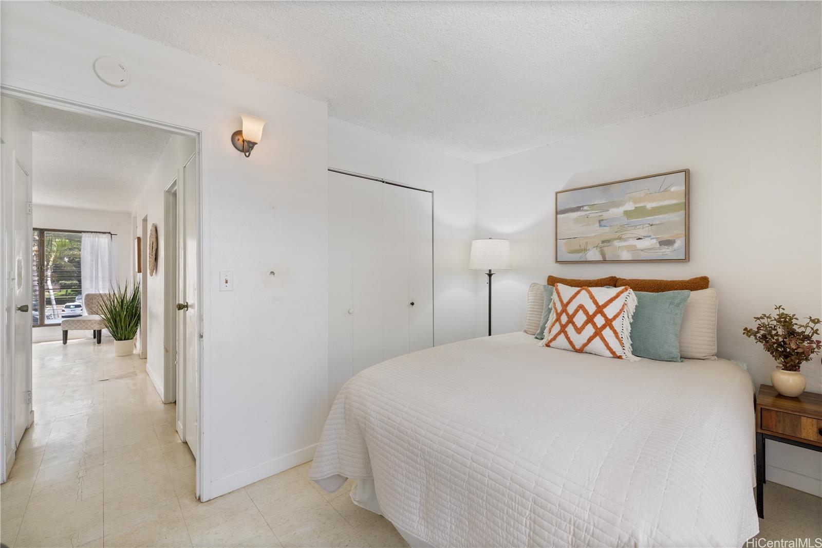 87-119 Helelua Street, Unit F204 Waianae, HI 96792 - Photo 18 of 24 a bedroom with a large bed and a painting on the wall