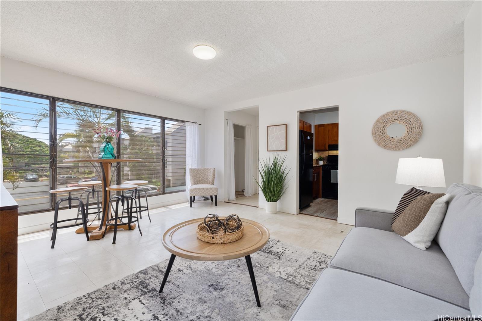 87-119 Helelua Street, Unit F204 Waianae, HI 96792 - Photo 2 of 24 a living room with furniture and a large window
