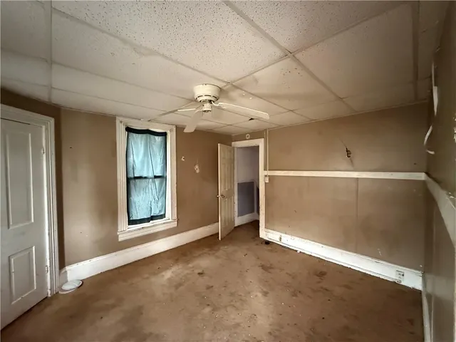 en empty room with windows and ceiling fan