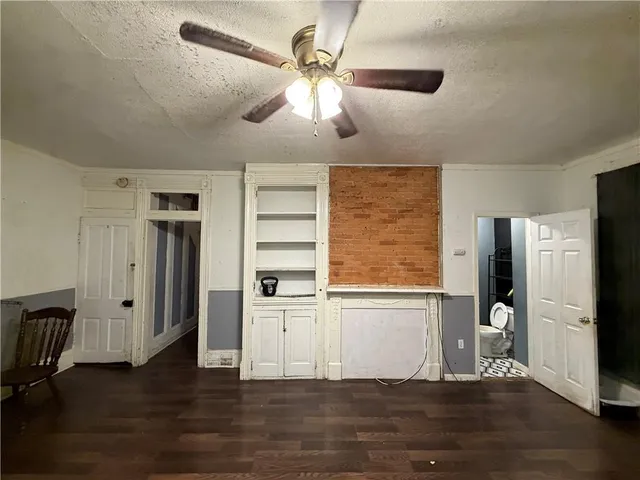a view of a kitchen with a fridge wooden floor and a ceiling fan