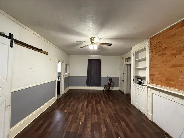 a very nice looking room with wooden floor and a ceiling fan